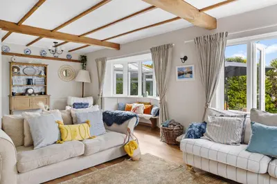 a living room with two white couches and windows at Blue Haze - Family accommodation with private beach access in Charlestown