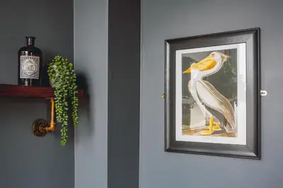 a picture of a bird on a wall with a bottle of wine at Smarties Guest House in Newquay