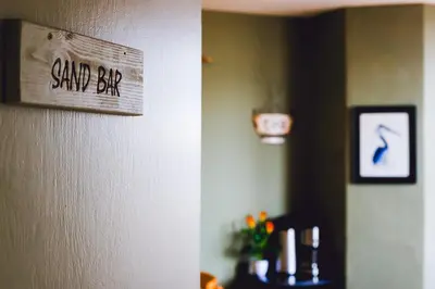 a sign on a wall that reads sand bar at Smarties Guest House in Newquay