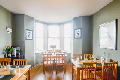 a dining room with a table and some chairs at Smarties Guest House in Newquay