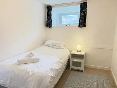 a small bedroom with a bed and a window at Lower Deck in St Ives