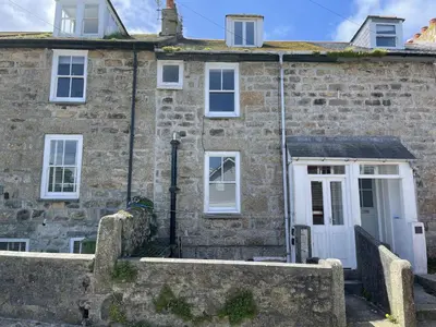 an old stone house with a white door at The Lookout in St Ives