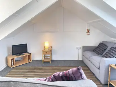 a living room with a couch and a tv at The Lookout in St Ives