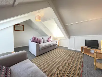 a living room with a couch and a tv at The Lookout in St Ives
