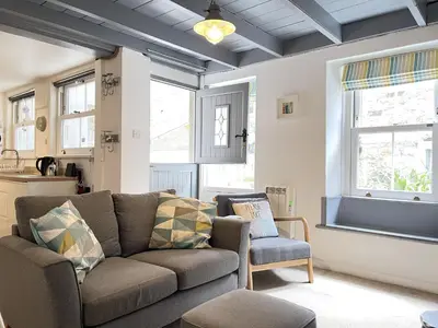 a living room with a couch and a chair at The Bolthole, a cosy, contemporary cottage! in St Ives