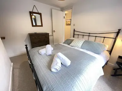 a bedroom with a bed with towels on it at The Bolthole, a cosy, contemporary cottage! in St Ives