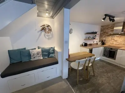 a small room with a bench and a table in a kitchen at The Bolthole, a cosy, contemporary cottage! in St Ives