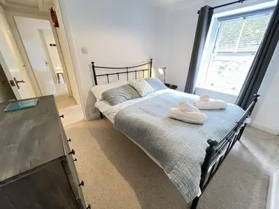 a bedroom with a bed with towels on it at The Bolthole, a cosy, contemporary cottage! in St Ives