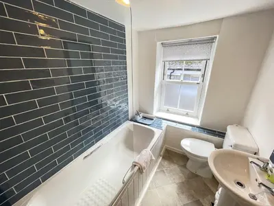 a bathroom with a tub and a toilet and a sink at The Bolthole, a cosy, contemporary cottage! in St Ives
