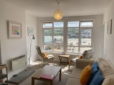a living room with a couch and a large window at 3 Sunnyside - amazing harbour views in St Ives