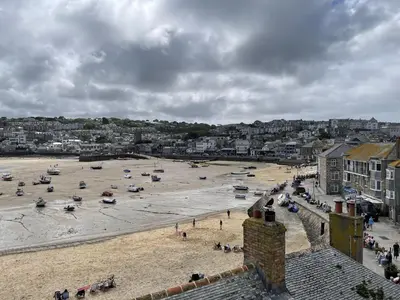 a beach with boats on the sand in a city at 3 Sunnyside - amazing harbour views in St Ives