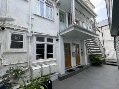 a white house with a staircase leading up to the front door at 3 Sunnyside - amazing harbour views in St Ives