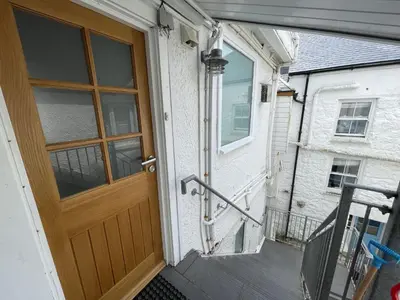 a wooden door on a house with a balcony at 3 Sunnyside - amazing harbour views in St Ives