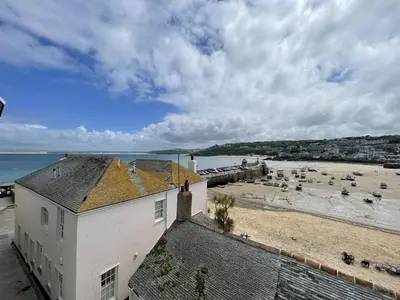 a view of a beach with a white building at 3 Sunnyside - amazing harbour views in St Ives