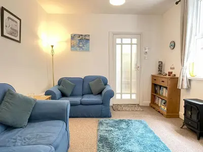 a living room with a blue couch and a table at An Marghty in St Ives