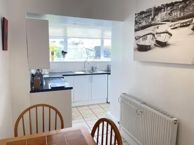 a kitchen with a table and a sink and a table and chairs at An Marghty in St Ives