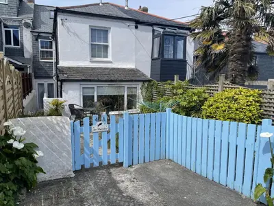 a blue gate in front of a white house at An Marghty in St Ives