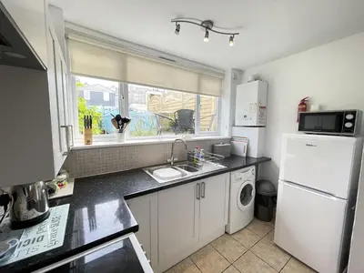 a kitchen with a sink and a white refrigerator at An Marghty in St Ives