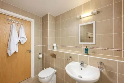 a bathroom with a sink and a toilet and a mirror at Number 2 in Lusty Glaze, Newquay in Newquay