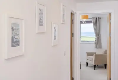 a hallway with a room with a chair and a window at Number 2 in Lusty Glaze, Newquay in Newquay