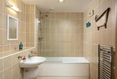 a bathroom with a sink and a bath tub at Number 2 in Lusty Glaze, Newquay in Newquay