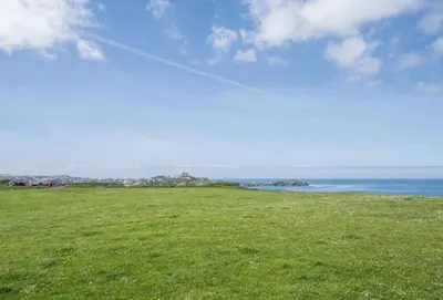 a field of green grass with the ocean in the background at Number 2 in Lusty Glaze, Newquay in Newquay