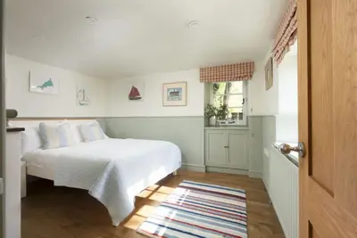 a bedroom with a white bed and a window at Sparnal Stitch and the Hideaway in Padstow