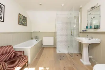 a bathroom with a tub and a shower and a sink at Sparnal Stitch and the Hideaway in Padstow