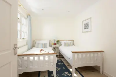 a bedroom with two beds and a window at Sparnal Stitch and the Hideaway in Padstow
