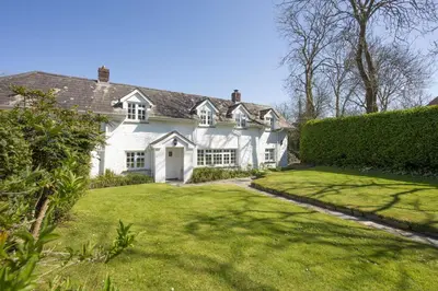 a white house with a large grass yard at Sparnal Stitch and the Hideaway in Padstow