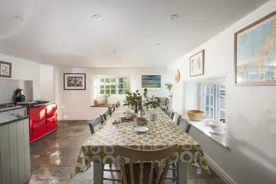 a kitchen and dining room with a table and chairs at Sparnal Stitch and the Hideaway in Padstow