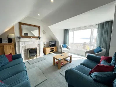 a living room with two blue couches and a fireplace at Upper Seaview in St Ives