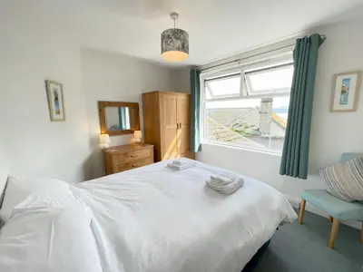 a bedroom with a white bed and a window at Upper Seaview in St Ives