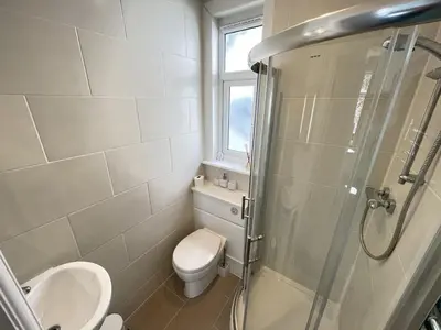 a bathroom with a shower and a toilet and a sink at Upper Seaview in St Ives