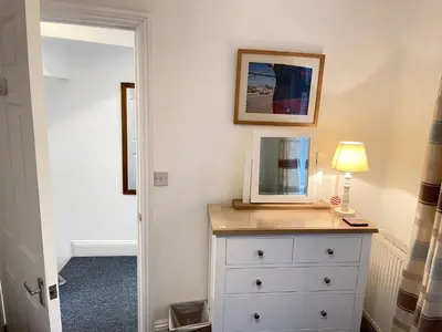 a bedroom with a dresser with a mirror and a lamp at Lower Seaview in St Ives