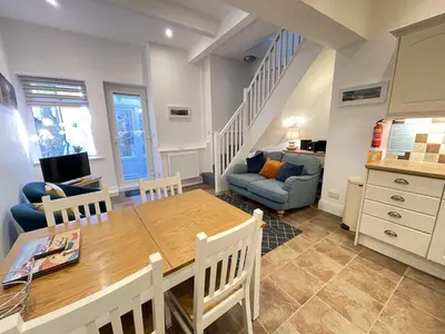 a kitchen and living room with a table and a couch at Lower Seaview in St Ives