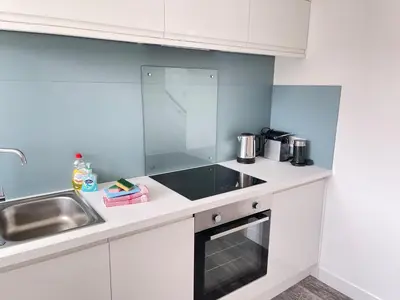 a white kitchen with a sink and a counter at 26 Piazza - stunning seaviews of Porthmeor beach in St Ives