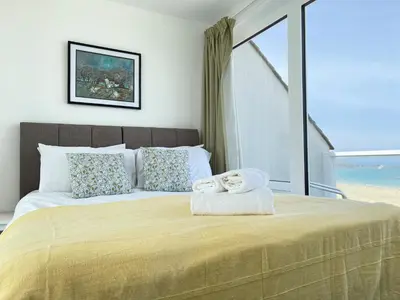 a bedroom with a bed with two towels on it at 26 Piazza - stunning seaviews of Porthmeor beach in St Ives