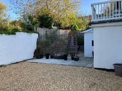 a backyard with a fence and potted plants at Lovely cottage in Penryn centre with parking in Penryn