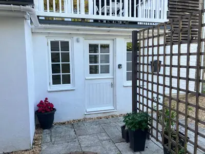 a white house with a white door and a fence at Lovely cottage in Penryn centre with parking in Penryn