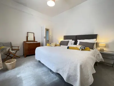 a bedroom with a large white bed with yellow pillows at Morvah - stunning views of the harbour and beyond in St Ives