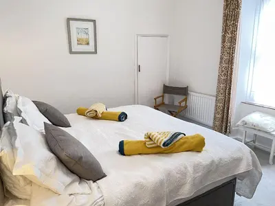 a bedroom with a bed with two towels on it at Morvah - stunning views of the harbour and beyond in St Ives