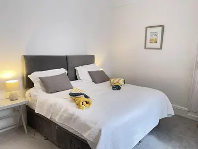 a bedroom with a bed with a stuffed animal on it at Morvah - stunning views of the harbour and beyond in St Ives