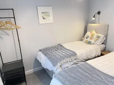 a bedroom with two beds and a mirror at Morvah - stunning views of the harbour and beyond in St Ives