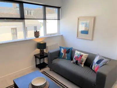 a living room with a couch and some windows at Dolly - a peaceful retreat in St Ives