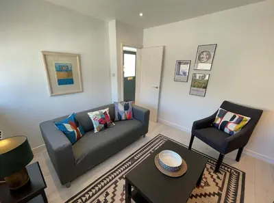 a living room with a couch and a chair at Dolly - a peaceful retreat in St Ives