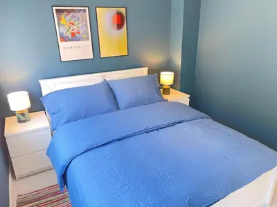 a blue bedroom with a bed with blue sheets and two lamps at Dolly - a peaceful retreat in St Ives