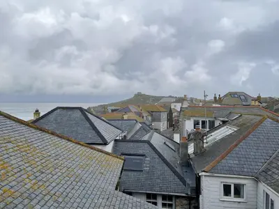 a group of roofs with the ocean in the background at The Green House in St Ives