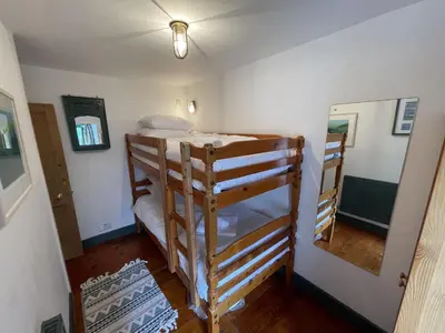 a room with two bunk beds and a mirror at The Green House in St Ives