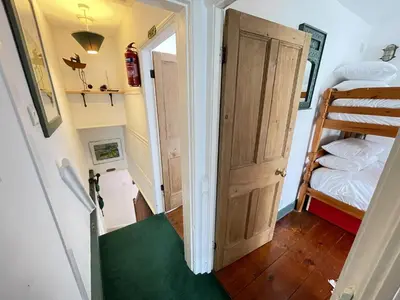 a stairway leading to a room with a bunk bed at The Green House in St Ives